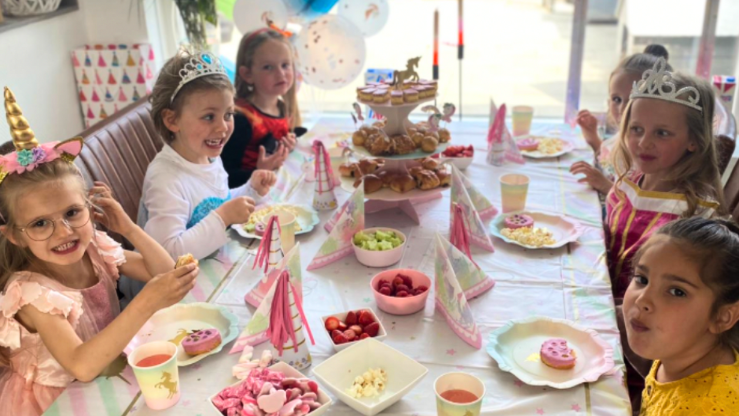 compleet kinderfeestje thuis, handig pakket voor een compleet kinderfeestje, op de afbeelding een groep meisjes aan tafel die een eenhoorn verjaardag vieren