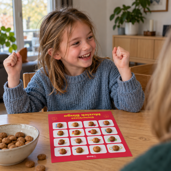 Een meisje juicht omdat haar muziekbingo-kaart vol ligt met pepernoten